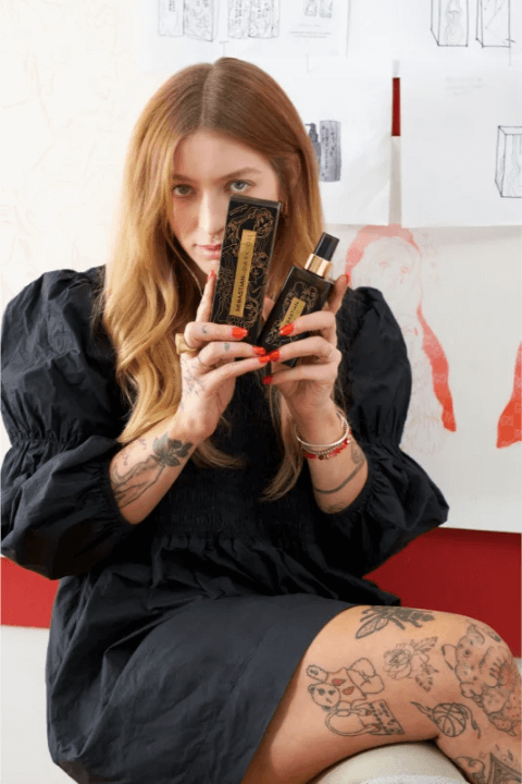 Woman holding Sebastian Professional Dark Oil Girl Knew York hair product in a stylish room.