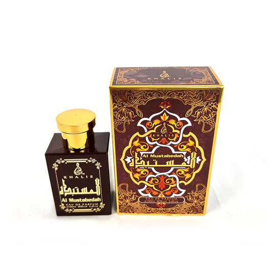 A perfume bottle with a gold cap next to its boxed packaging, both featuring ornate designs.
